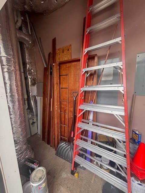 Closet before — cluttered with doors, ladders, and supplies