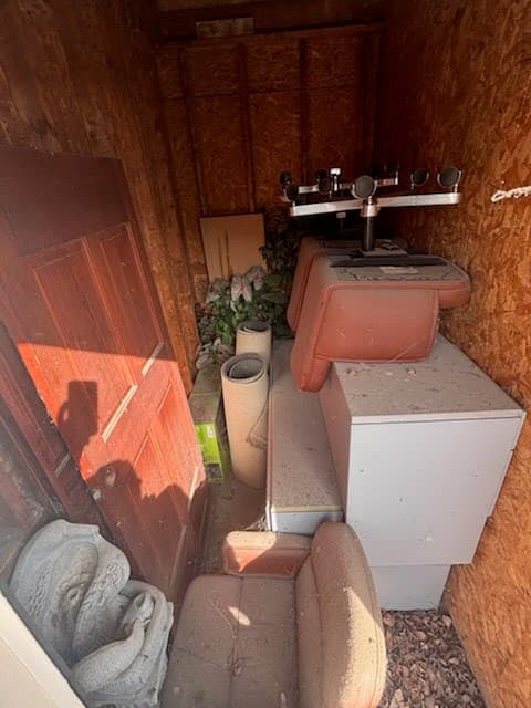 Storage unit before — packed with furniture and debris