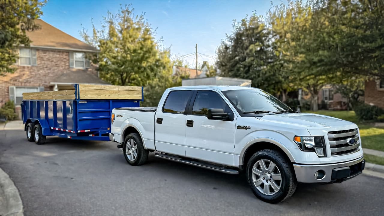 Clean Slate Junk Removal — pearl white Ford F-150 with blue dump trailer